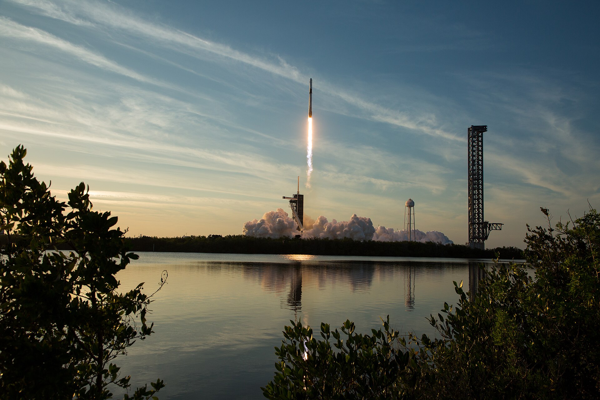 Une fusée Falcon 9 de SpaceX décolle de nuit en Floride, panache de flammes au-dessus du pas de tir